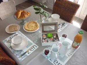 una mesa cubierta con una mesa con comida y bebida en Les Champs de Tracy, en La Graverie