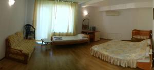 a room with two beds and a couch and a chair at Harmony Beach Family Hotel in Nesebar +7 photos