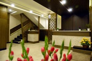 a lobby with a staircase and flowers in the foreground at The Hydel Park - Business Class Hotel - Near Central Railway Station in Chennai