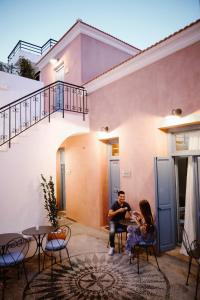 een man en een vrouw die voor een huis zitten bij Blue Jasmine Suites in Rhodos-stad