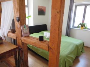 1 dormitorio con cama con dosel y sábanas verdes en Privatzimmer Othmarsweg, en Naumburg