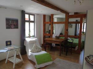 ein Wohnzimmer mit einem Bett und einem Schreibtisch sowie ein Schlafzimmer in der Unterkunft Privatzimmer Othmarsweg in Naumburg