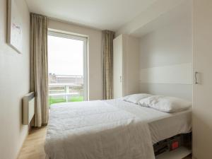 a bedroom with a bed and a large window at Penthouse with 2 terraces and sea casino views in Middelkerke