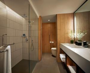 a bathroom with a shower and a toilet and a sink at PARKROYAL Penang Resort in Batu Ferringhi