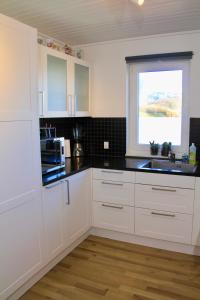 
a kitchen with white cabinets and white appliances at Nordic Inn Thorshavn in Tórshavn
