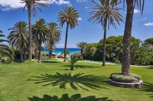 a park with palm trees and the ocean in the background at Hotel Porto Santo & Spa in Porto Santo
