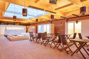 a room with tables and chairs and a couch at Hotel Porto Santo & Spa in Porto Santo