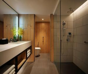 a bathroom with a shower and a sink and a toilet at PARKROYAL Penang Resort in Batu Ferringhi