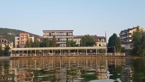 a boat on a river with buildings in the background at Hotel Millennium in Pogradec