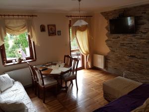 una sala de estar con una mesa, sillas y un sofá en Apartman Cici, en Zlatibor