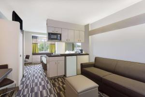 a living room with a couch and a kitchen at Microtel Inn & Suites by Wyndham in Sandston