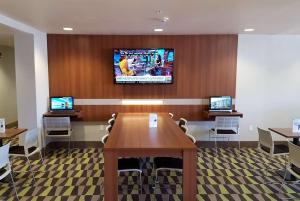 Sala de conferencias con mesa y TV en la pared en Microtel Inn & Suites by Wyndham Bellevue, en Bellevue