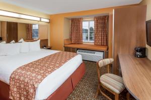 una camera d'albergo con un letto grande e una scrivania di Microtel by Wyndham South Bend Notre Dame University a South Bend