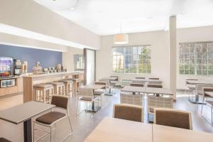 a restaurant with tables and chairs and windows at Microtel Inn & Suites by Wyndham Ocean City in Ocean City