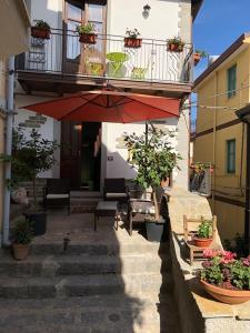 un edificio con balcón y una escalera con plantas en Al castello San Piero Patti, en San Piero Patti