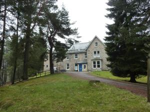 una gran casa de piedra con entrada en Braemar Youth Hostel, en Braemar