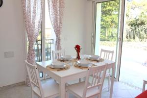 a white dining room with a white table and chairs at Casa Laura in Imperia