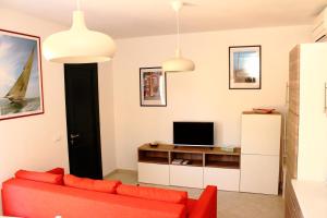 a living room with a red couch and a tv at Casa Laura in Imperia