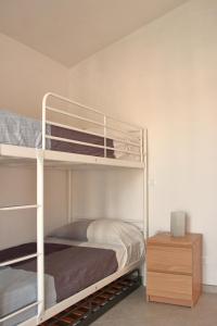a bedroom with two bunk beds and a night stand at Casa Laura in Imperia