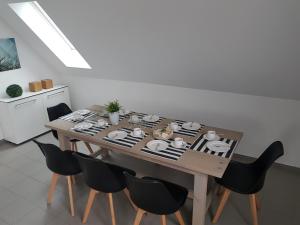 ビューズムにあるFerienwohnung dat witte hus 2のダイニングルームテーブル(黒い椅子付)、食器類付きテーブル