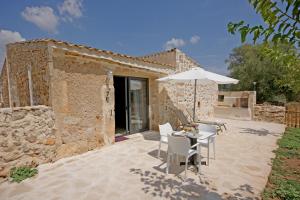 a patio area with a table, chairs, and umbrella at Agroturisme Rafal Nou in Manacor