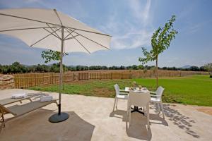 a patio area with chairs, tables and umbrellas at Agroturisme Rafal Nou in Manacor