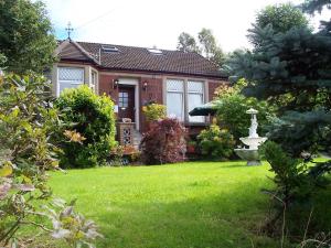 una casa con un patio verde con una fuente en Sunnyside B&B, en Balloch