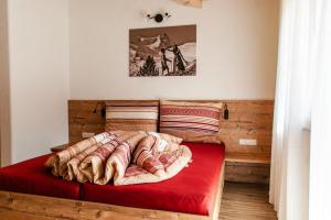 łóżko z czerwonym kocem na górze w obiekcie Ferienhaus Sennerhäusl w mieście Sautens