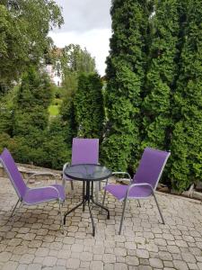 dos sillas moradas y una mesa y una mesa y sillas en Apartman Cici, en Zlatibor