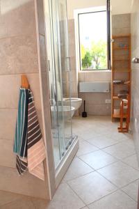 a bathroom with a shower and a toilet and a window at Casa Laura in Imperia