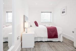 a white bedroom with a bed and a mirror at Roomspace Serviced Apartments - The Legacy in Brighton & Hove