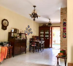 uma sala de estar com uma mesa e uma sala de jantar em Pouso Flor de Manacá em Tiradentes