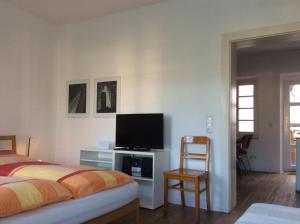 a bedroom with a bed and a flat screen tv at Ferienwohnung An den Kaiserthermen in Trier