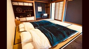 una camera da letto con un letto con una coperta blu sopra di SIMA inn a Onomichi