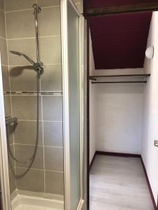 a bathroom with a shower with a glass door at Aux lettres du lavoir in La Rivière Saint Sauveur