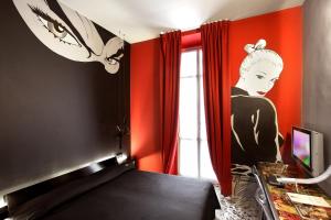 トリノにあるアート ホテル ボストンの壁に女性の絵画が描かれたベッドルーム