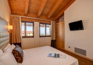 una camera da letto con un letto con un libro sopra di TH Lazise - Hotel Parchi Del Garda a Lazise