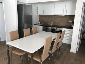 a kitchen with a white table and chairs at alojamento Xa andar in Nazaré