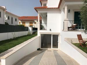 a white house with a balcony and a walkway at alojamento Xa andar in Nazaré