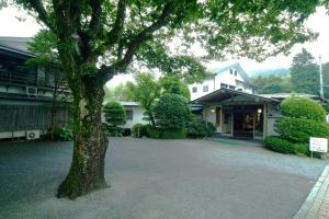 un grand arbre devant une maison dans l'établissement Mitake, à Hakone