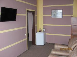 a living room filled with furniture and a tv at Hotel Vinnytsia Sawoy in Vinnytsya