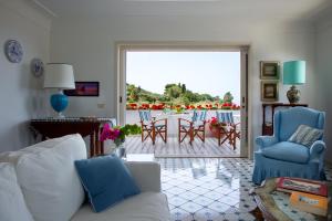 a living room with a white couch and blue chairs at Riolinciano14 B&B in Anacapri