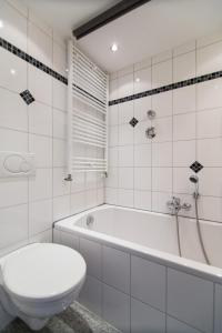 ein Badezimmer mit Toilette, Badewanne und Waschbecken in der Unterkunft Oldtown Apartment Andreasstrasse in Düsseldorf
