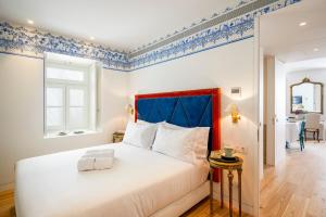 a bedroom with a large bed with a blue headboard at Residentas Aurea in Lisbon