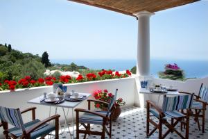 een patio met tafels, stoelen en bloemen bij Riolinciano14 B&B in Anacapri