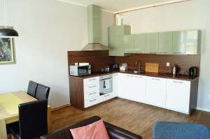 a kitchen with white cabinets and a table with chairs at Apartmány Mary in Litoměřice