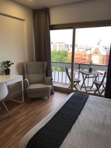 リスボンにあるRepublica83-Campo Pequeno Homeのリビングルーム(ソファ、椅子付)、バルコニーが備わります。