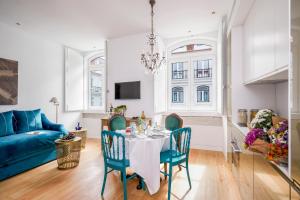 a living room with a table and chairs and a blue couch at Residentas Aurea in Lisbon