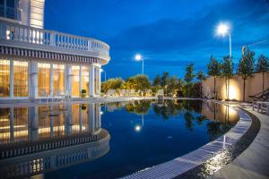 a building with a swimming pool at night at Hotel Villa Pascucci in Durrës