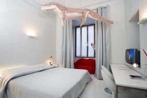 een slaapkamer met een wit bed en een rode stoel bij Art Hotel Boston in Turijn